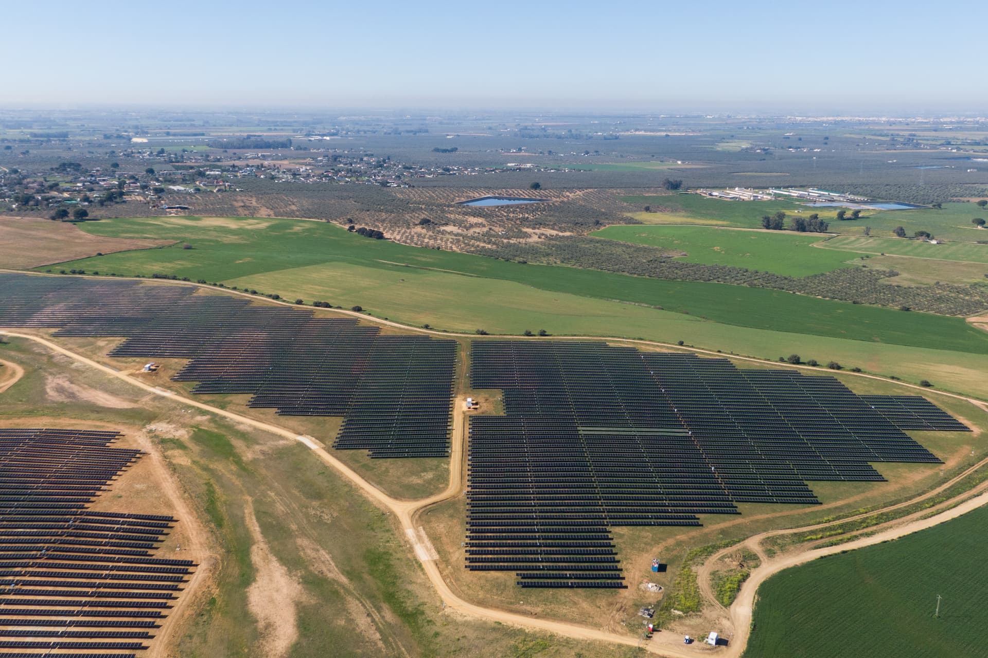 an aerial shot of the country side with lots of solar panels