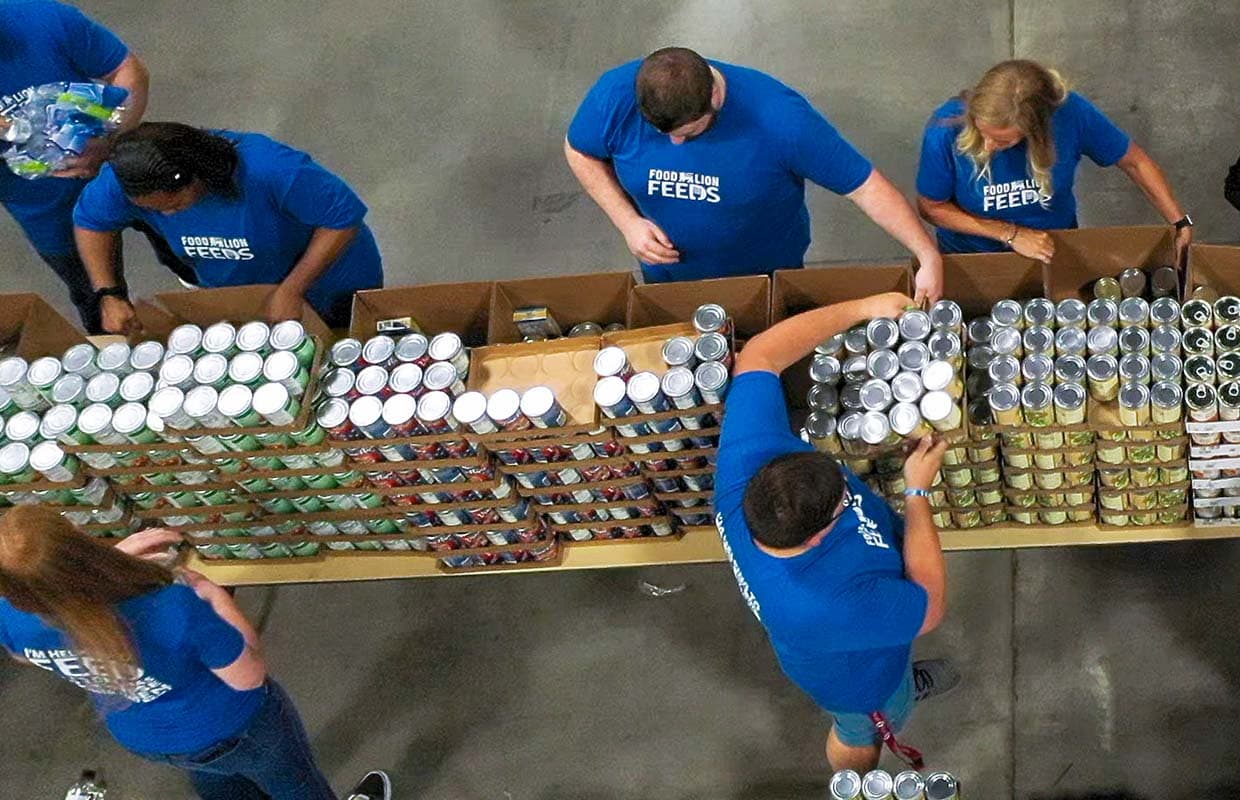 a shot looking down on employees wearing blue tshirts packing boxes