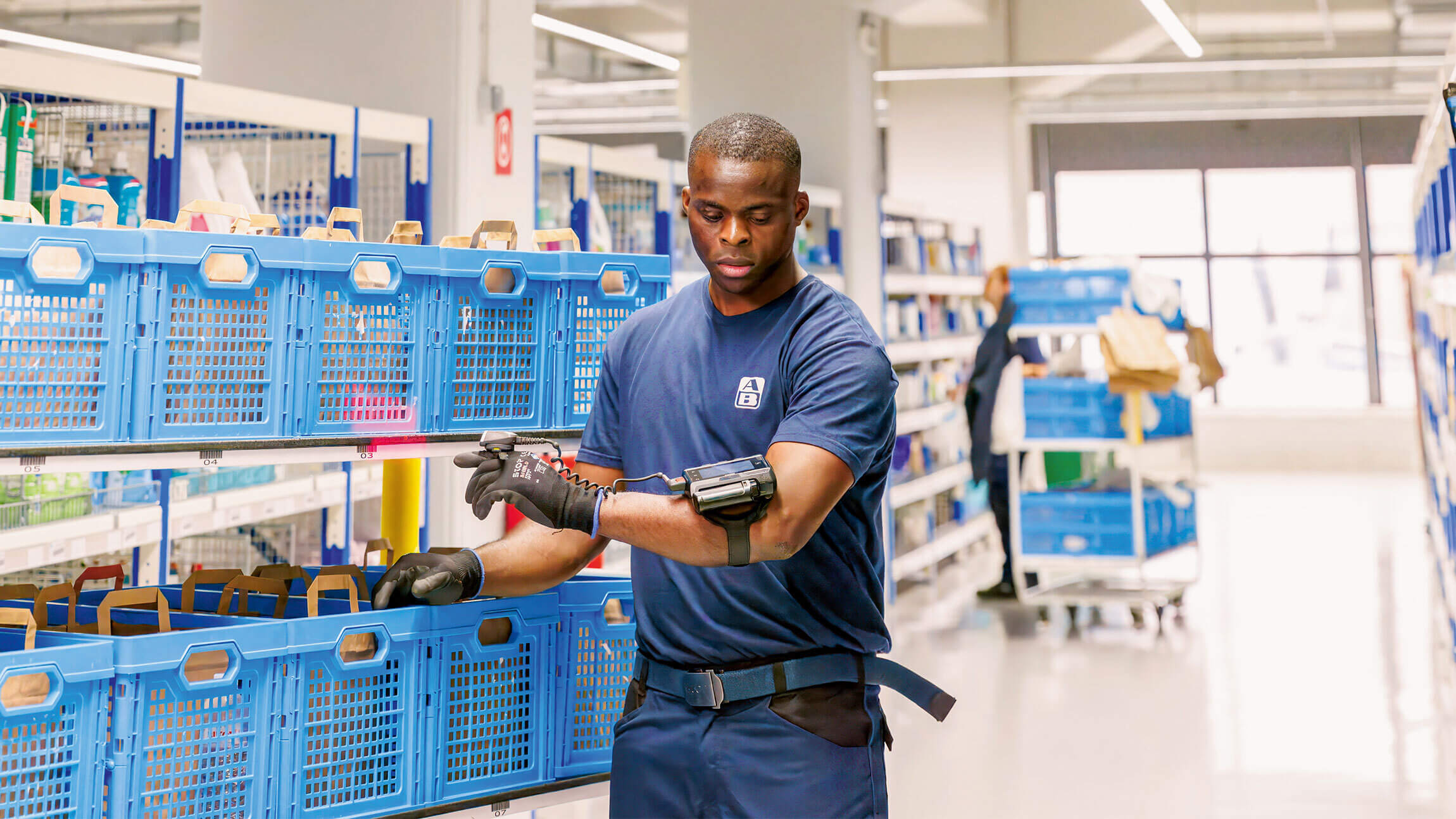 A man working in a supermarket checking a device