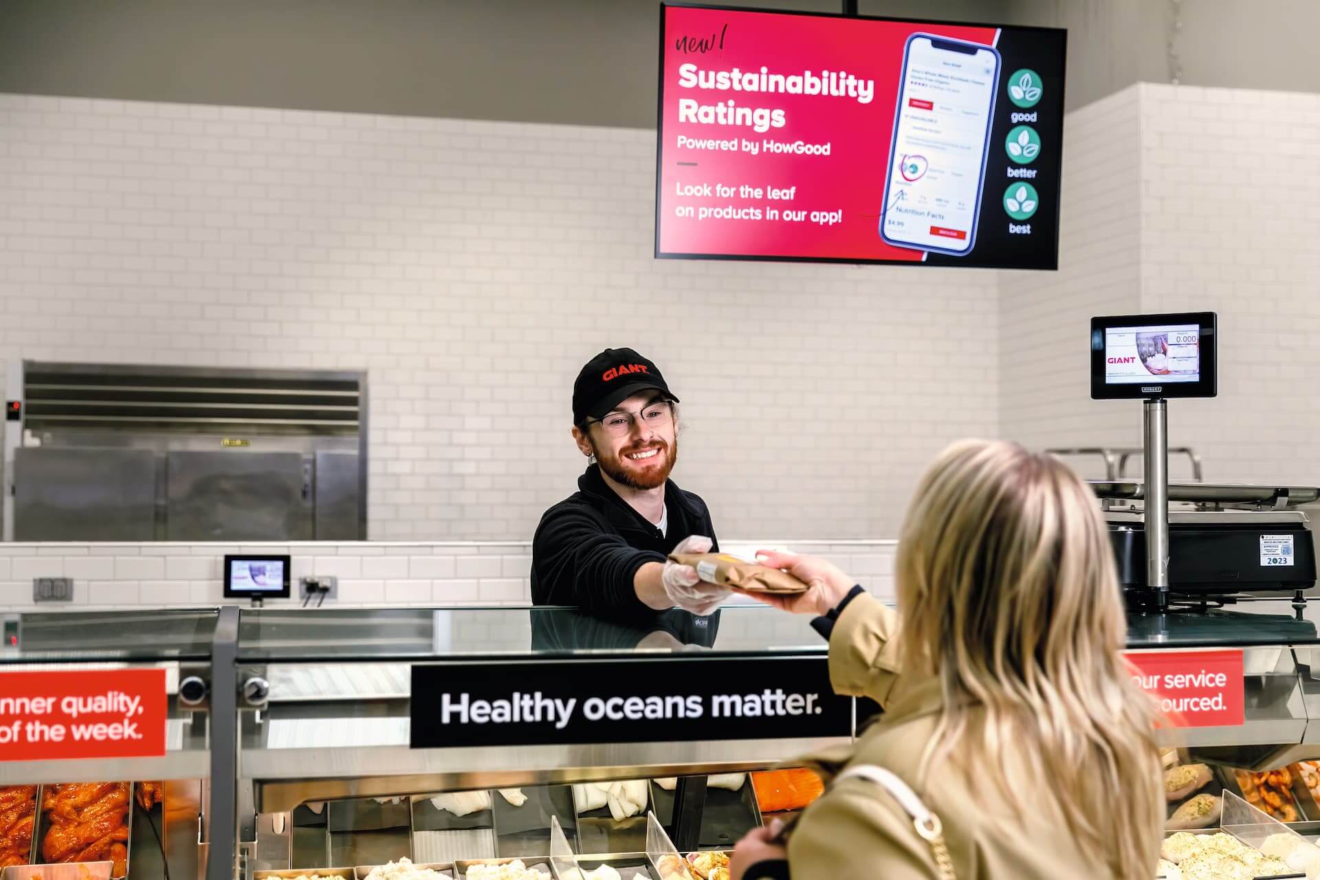 A man taking payment for some shopping over the counter